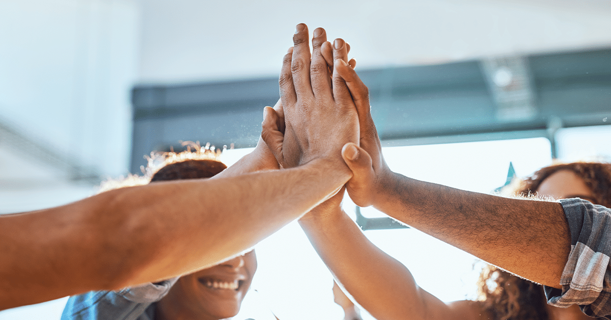 four people sharing a high-five